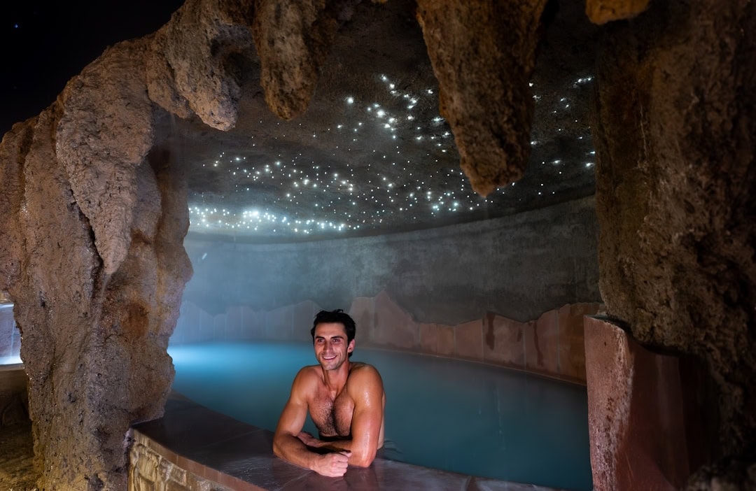 Indoor hot springs pool with glowing lights and rocky cave ceiling at The Springs Resort in Pagosa S.