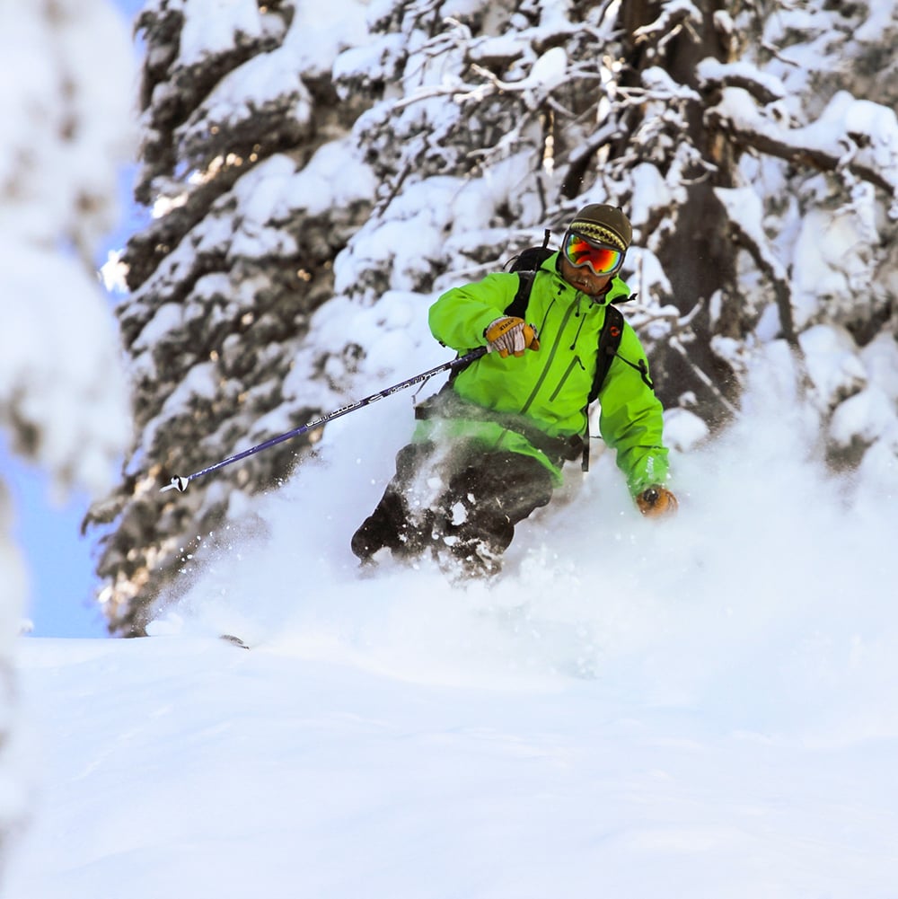 Male skier in a neon green jacket, with 