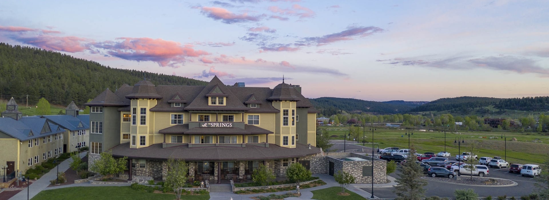 Exterior of The Springs Resort surrounded by greenery during sunset