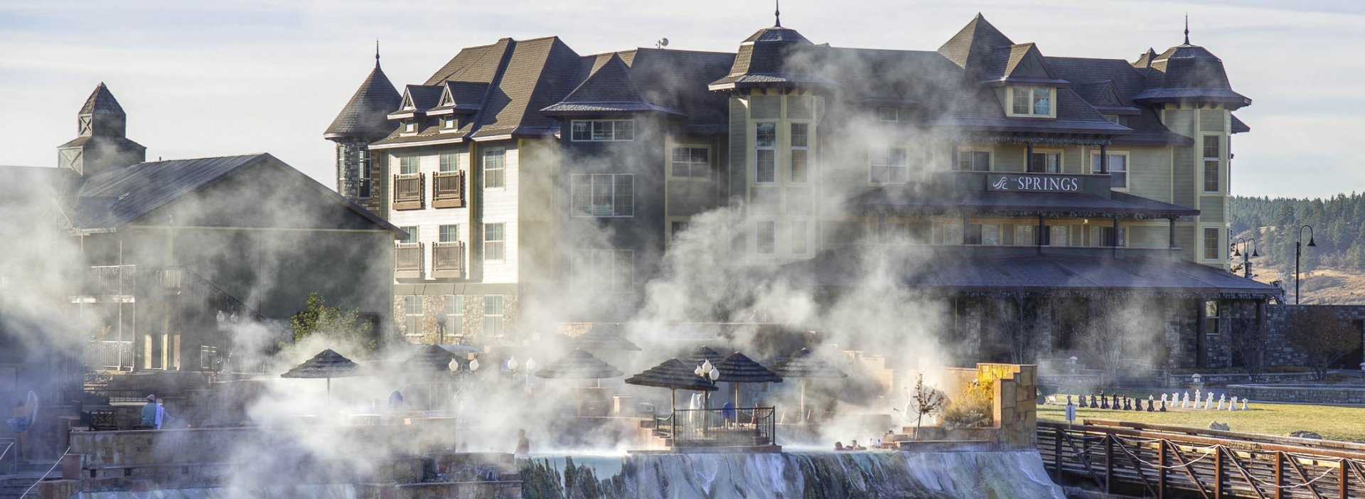 The exterior of the Springs Resort as steam rises from the front hot spring pool