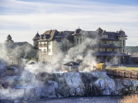 The exterior of the Springs Resort as steam rises from the front hot spring pool