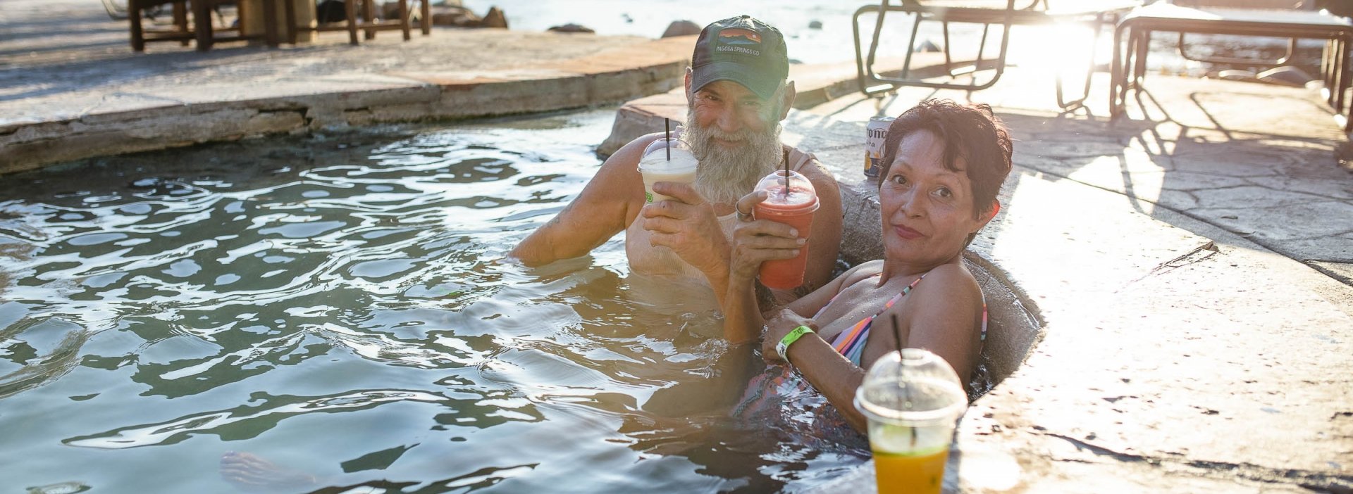 A couple enjoying their drinks on the pool