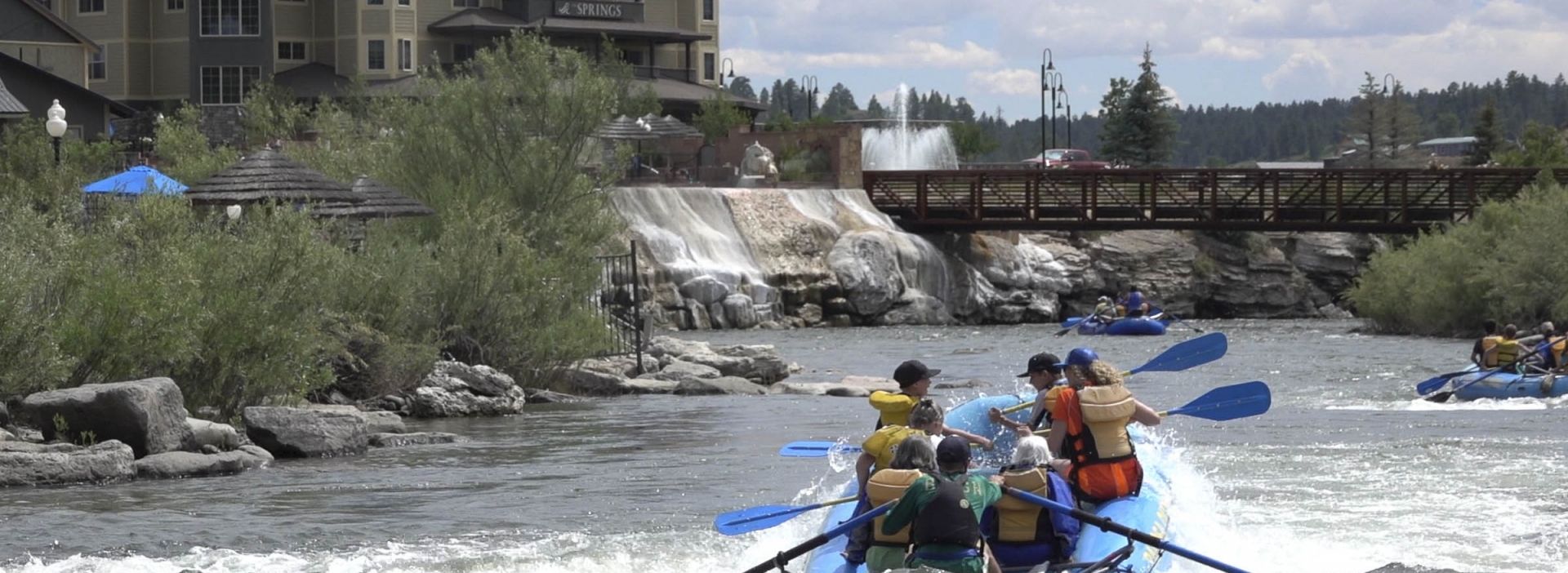 Back shot of group river rafting in San Juan River next to The Springs Resort