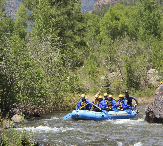 A group river rafting in the water