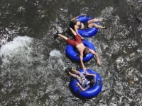 Three people floating on inflatable rings in the water