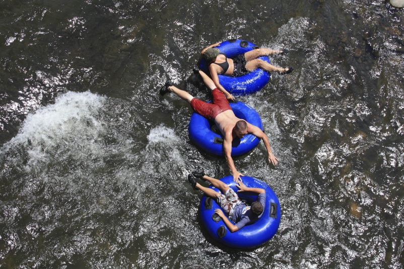Three people floating on inflatable rings in the water