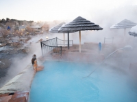 Woman sitting on the edge of a soaking pool in winter