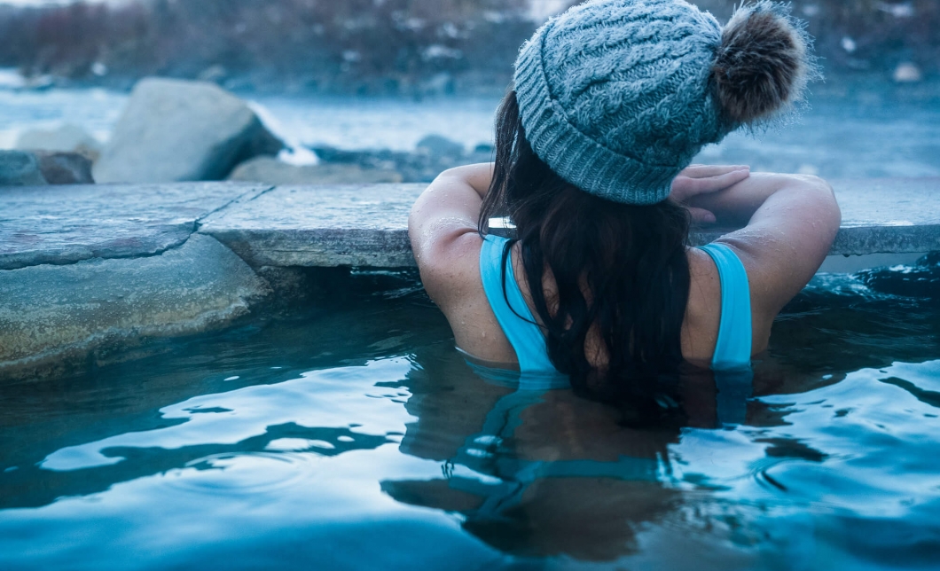 Young woman soaking in a hot spring at The Springs Resort