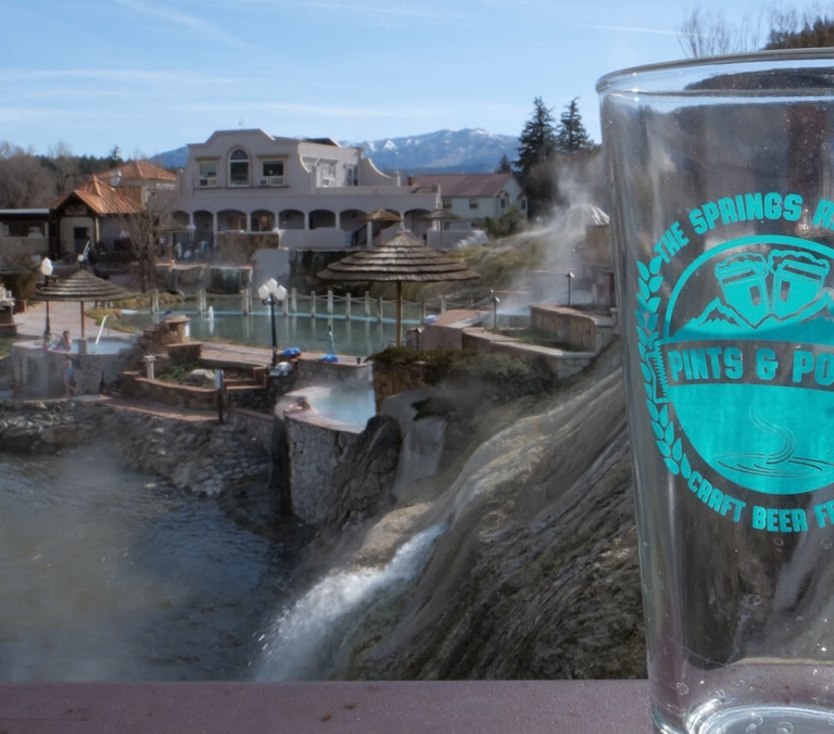 A clear glass with a turquoise logo reading 