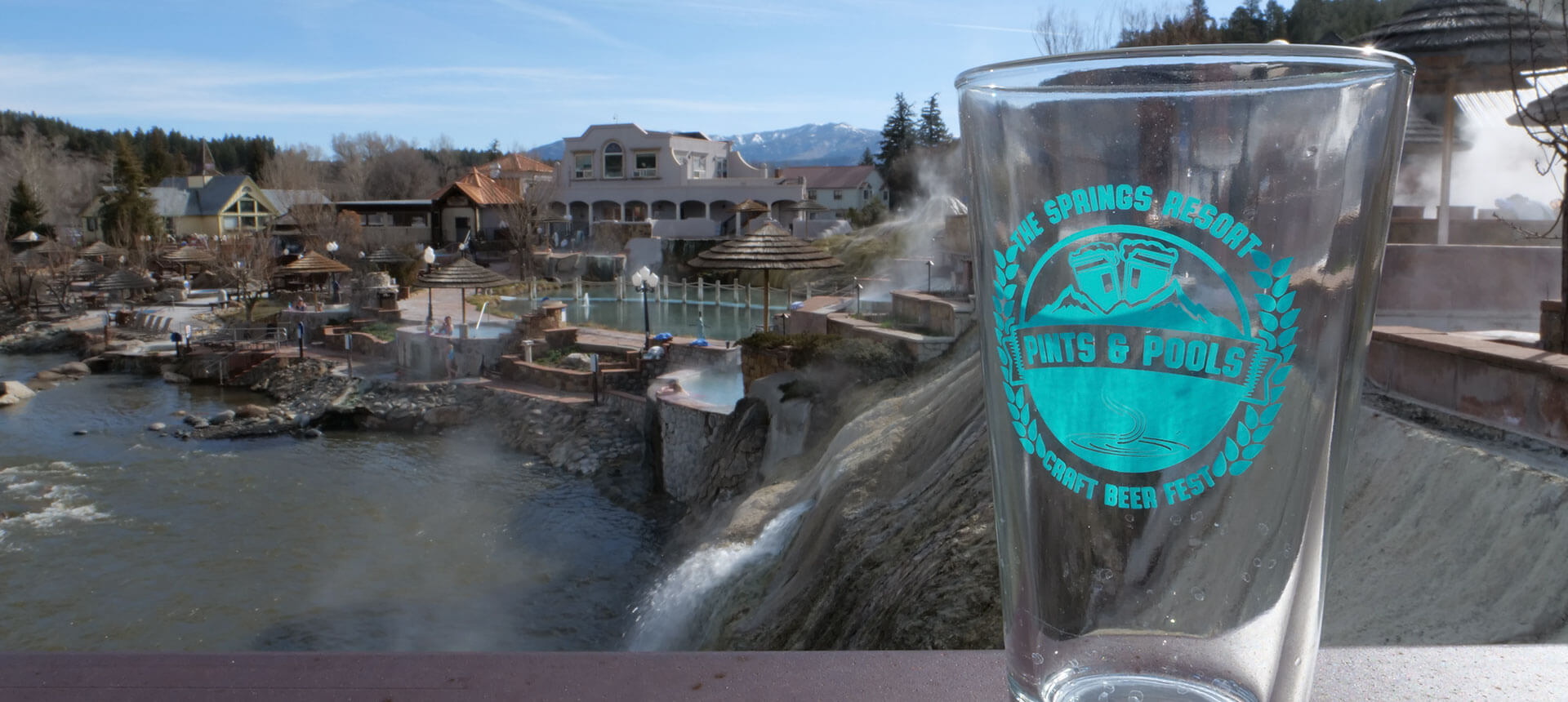 A clear glass with a turquoise logo reading 