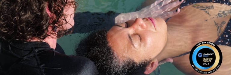A person floats face-up, eyes closed, supported by another in clear teal water.
Text: BEST SPA RESORT 10BEST USA TODAY READERS' CHOICE 2023 #1 - THE SPRINGS RESORT & SPA.