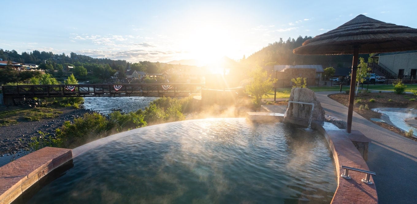 Relaxing hot spring pool at The Springs Resort during sunset.