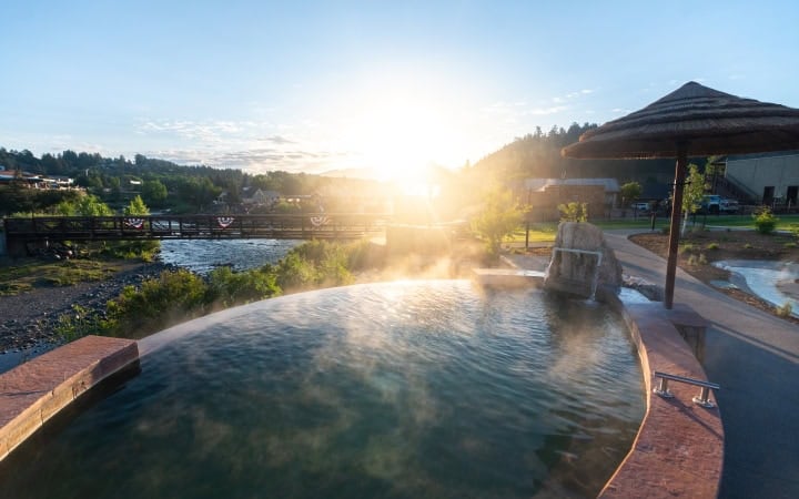 Relaxing hot spring pool at The Springs Resort during sunset.