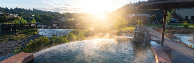 Relaxing hot spring pool at The Springs Resort during sunset.