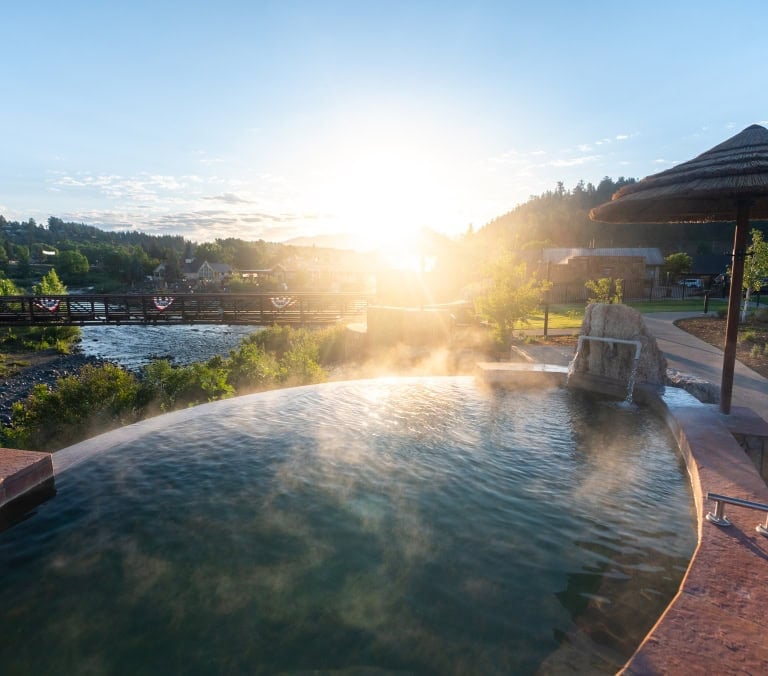 Relaxing hot spring pool at The Springs Resort during sunset.