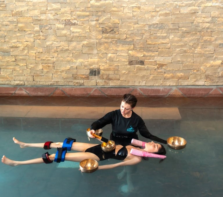 Relaxing aqua therapy session at The Springs Resort's pool with a therapist.