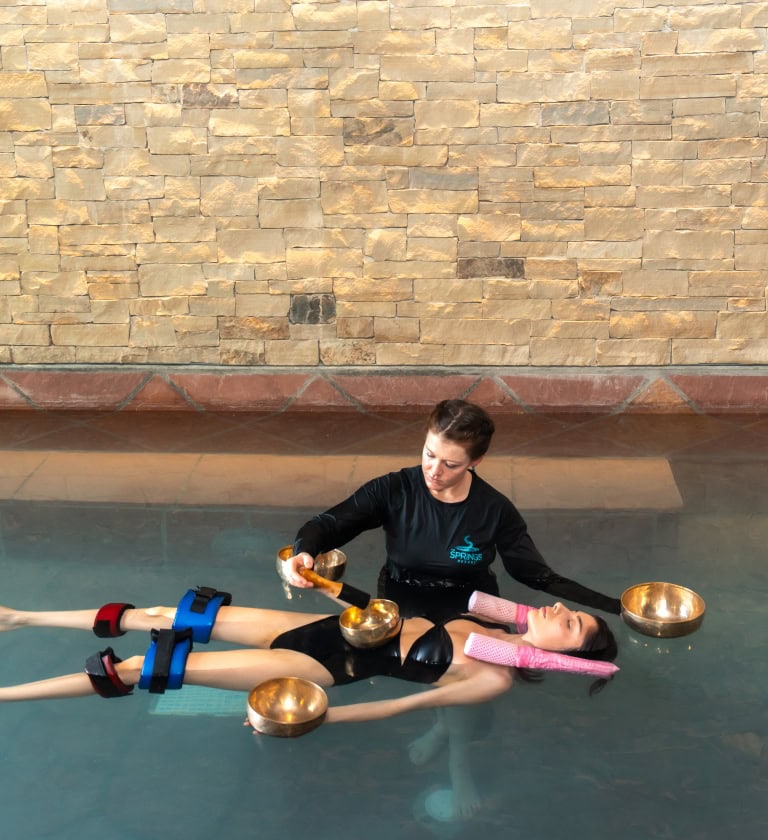 Relaxing aqua therapy session at The Springs Resort's pool with a therapist.