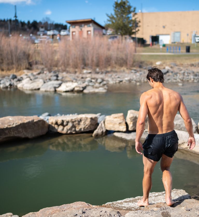 Man enjoying a hot spring at The Springs Resort during Cold Rush season.