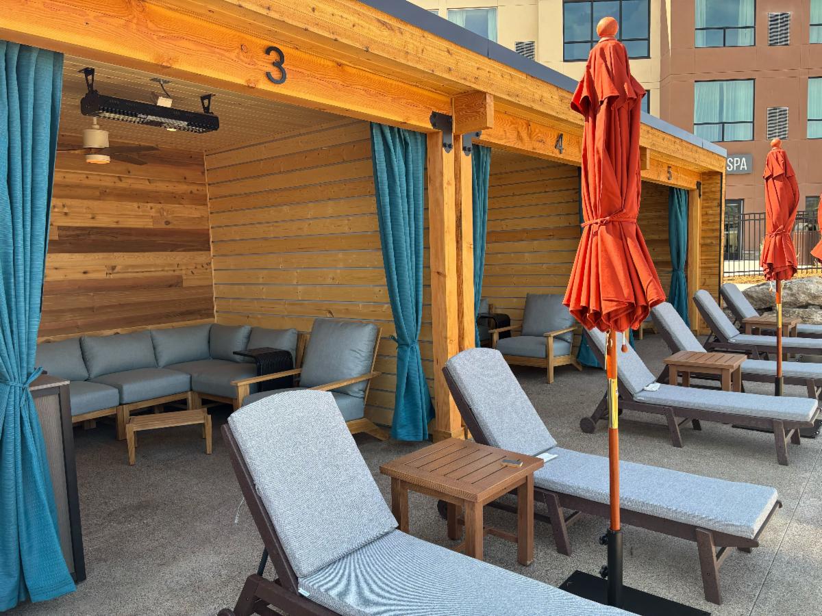 Wooden cabanas with blue curtains line a resort pool area, featuring lounge chairs and closed orange umbrellas. Text: 3, 4, 5, SPA.