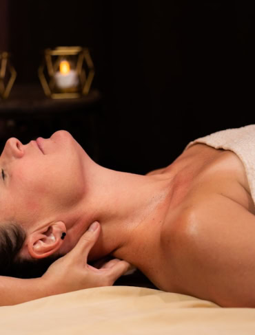 Woman receiving a hot stone massage in a spa setting at The Springs Resort, Pagosa Springs, Colorado.
