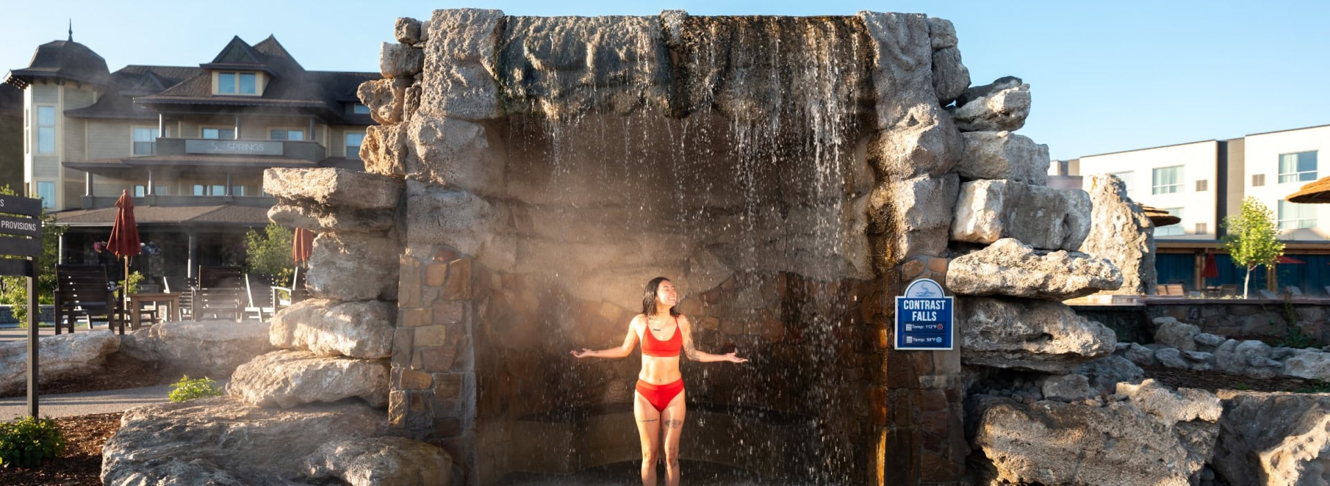Woman enjoying the hot mineral springs waterfall at The Springs Resort in Pagosa Springs, Colorado.