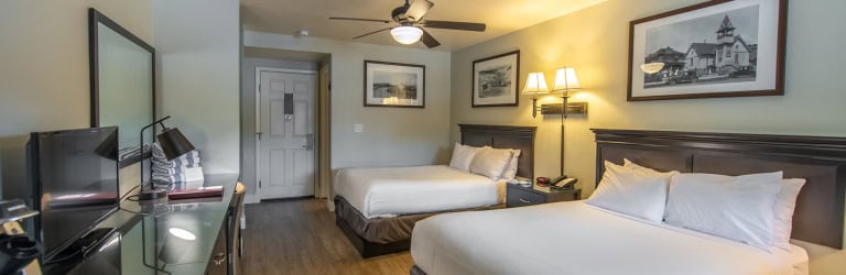 Comfortable hotel room at The Springs Resort with two queen beds and modern decor.