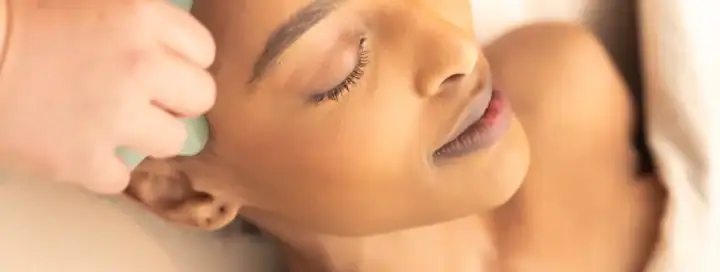 Woman receiving a soothing facial massage at The Springs Resort spa.