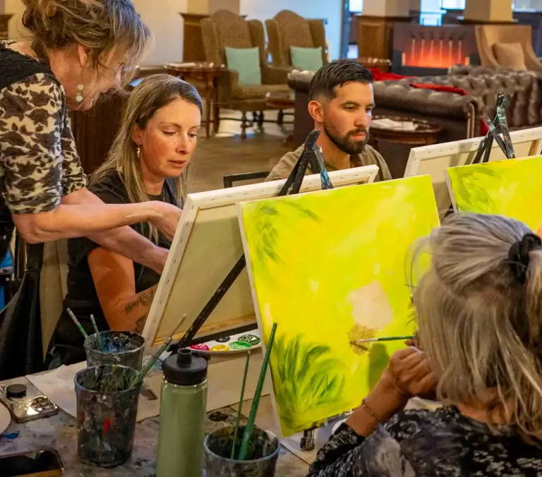 People painting colorful artwork during onsite Picasso painting class at The Springs Resort.