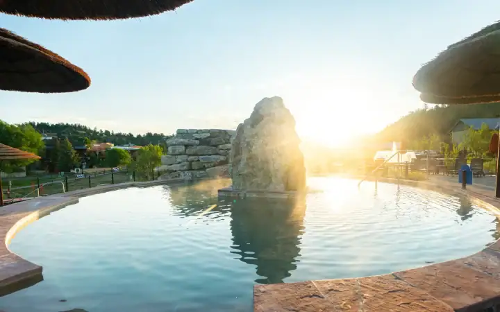 Relaxing hot spring pool at The Springs Resort with scenic sunset view.