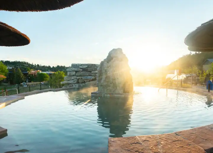 Relaxing hot spring pool at The Springs Resort with scenic sunset view.