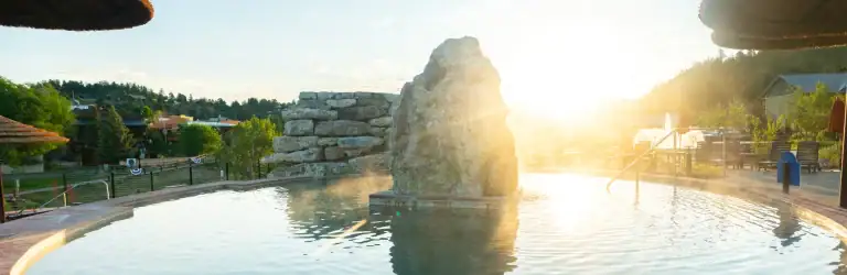 Relaxing hot spring pool at The Springs Resort with scenic sunset view.