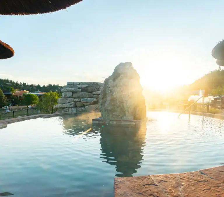 Relaxing hot spring pool at The Springs Resort with scenic sunset view.